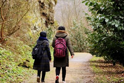 Rear view of women walking on footpath