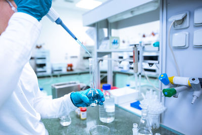 Midsection of scientist experimenting at laboratory