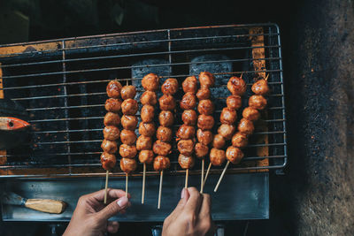 Midsection of person preparing food on barbecue grill