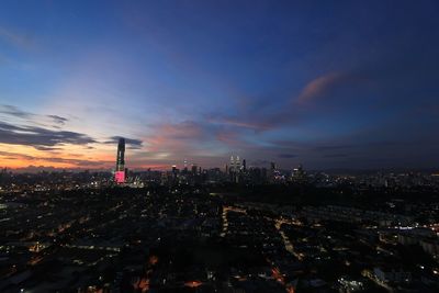 Aerial view of illuminated buildings against sky at night