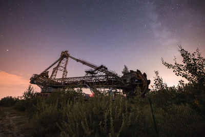 Low angle view of crane against sky at night