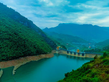 Scenic view of river amidst mountains against sky