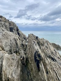 Rock formations on shore against sky