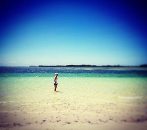 Man on beach against clear blue sky