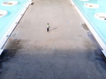 High angle view of woman walking on footpath amidst water