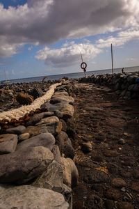 Scenic view of rocks on shore against sky