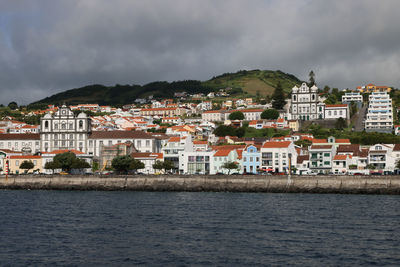 Town by sea against sky