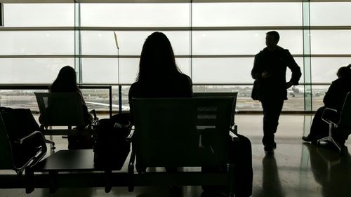 Rear view of silhouette people walking at airport