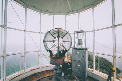 Ferris wheel by sea against clear sky seen through window