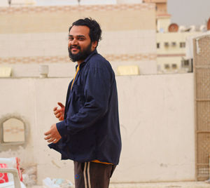 Young man standing against wall