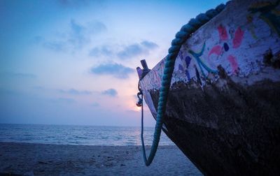 Fishing boat on beach against sky