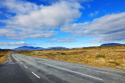 Road leading towards mountain against sky