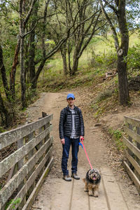Man walking a dog through a forest in oakland, california