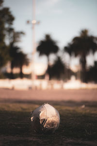 Close-up of ball on field against sky during sunset