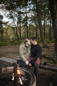 Couple sitting near campfire