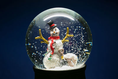 Close-up of snow globe against blue background