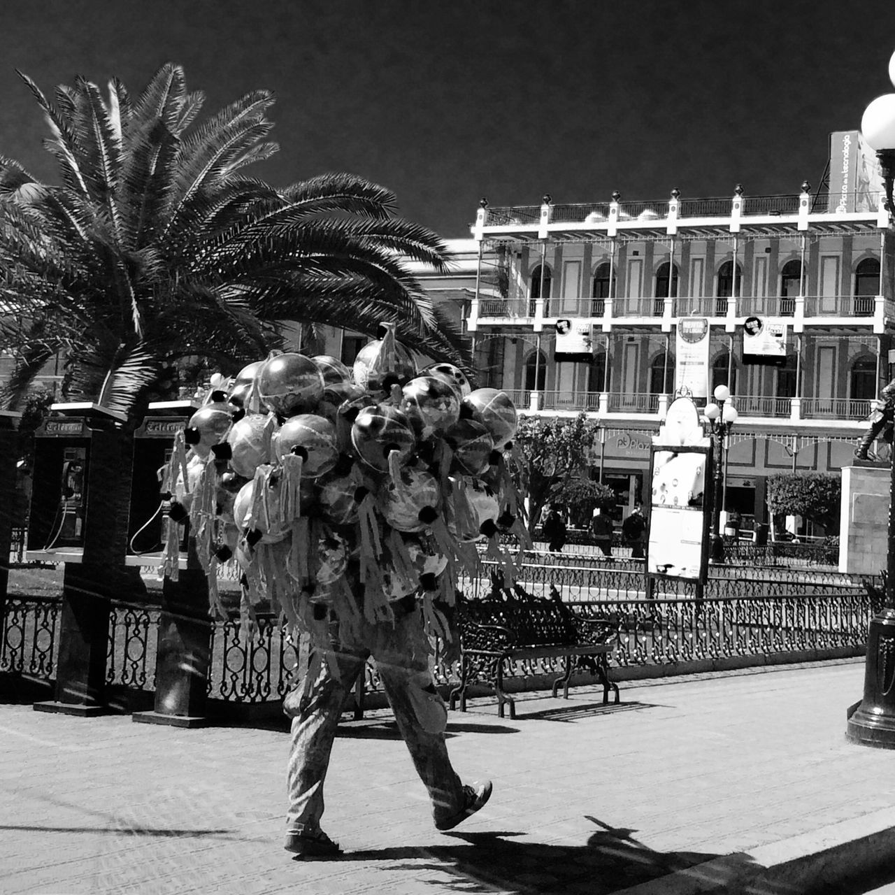 building exterior, architecture, built structure, city, clear sky, tree, men, incidental people, outdoors, city life, street, person, residential building, lifestyles, night, sunlight, residential structure, palm tree, shadow