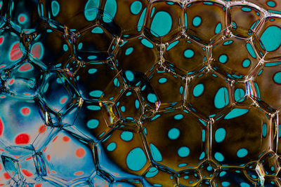 Macro shot of water oil emulsion over colored background