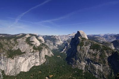 Panoramic view of rocky mountains against blue sky