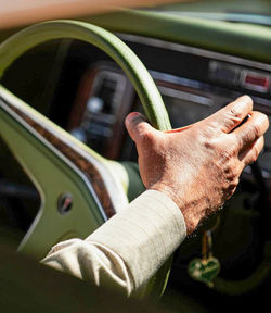 Cropped hand of man driving car