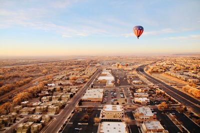 Aerial view of hot air balloon flying over city
