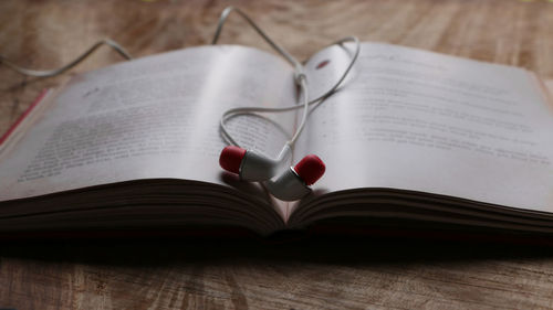 Close-up of headphones in book on table