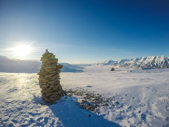 Scenic view of snow covered landscape against clear blue sky