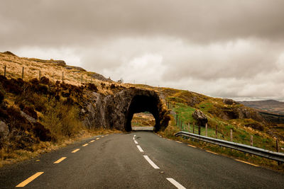 Road by mountain against sky