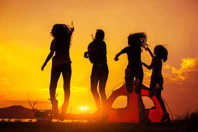 Silhouette people against sky during sunset