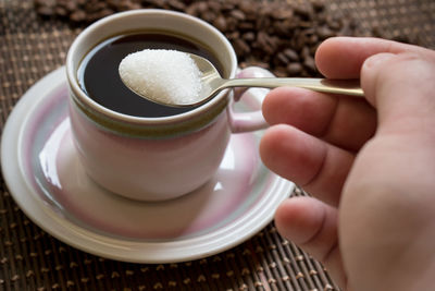 Cropped image of hand holding coffee cup