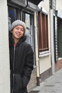 Portrait of smiling girl standing in city during winter