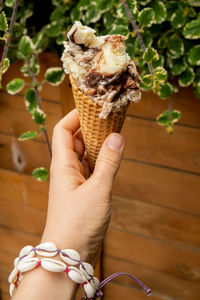 Female hand holding delicious american vanilla chocolate ice cream. tasty homemade icecream gelato