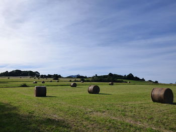 Hay bales on field against sky