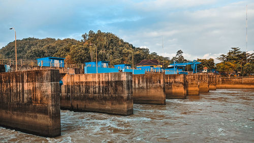 Built structure on river against sky