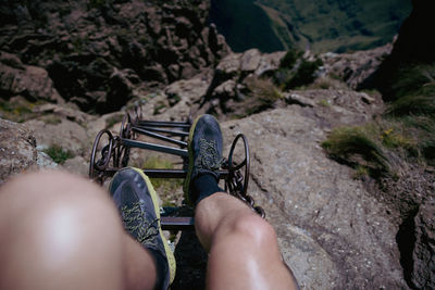 Low section of woman sitting on rock