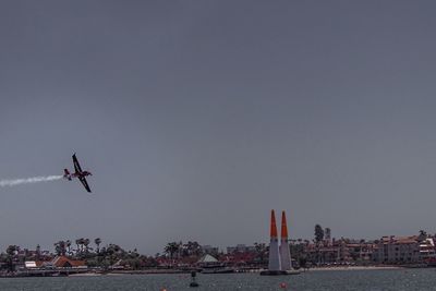 Airplane flying over sea against sky