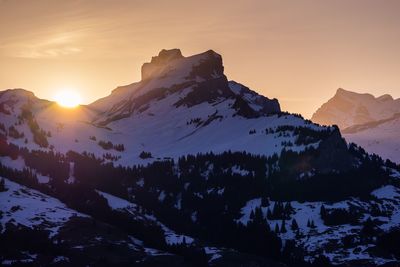 Scenic view of snowcapped mountains against sky during sunset