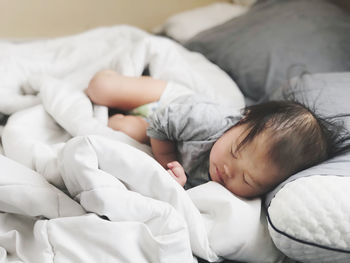 Cute baby sleeping on bed at home