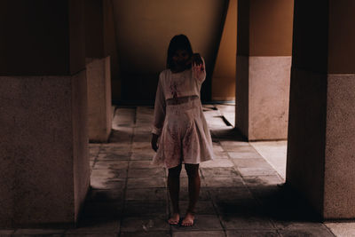 Full length of young woman with halloween make-up standing in corridor