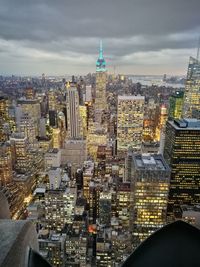 Aerial view of city buildings against cloudy sky