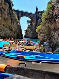 Boats moored on bridge against rock formation