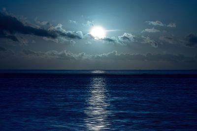 Scenic view of sea against moon in sky at night