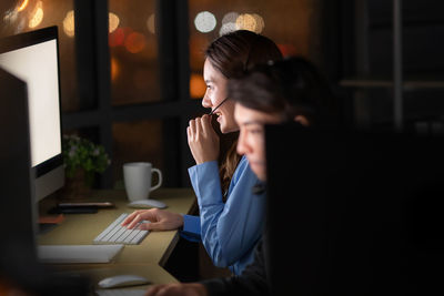 Woman using mobile phone while sitting on table