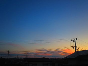 Silhouette electricity pylon against romantic sky at sunset