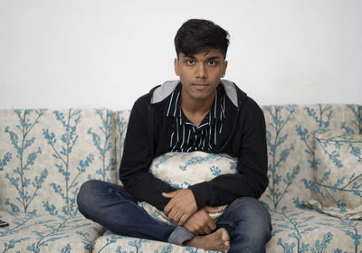 Portrait of young man sitting at home