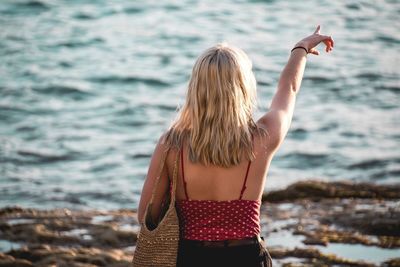 Rear view of woman standing at beach