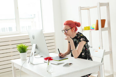 Woman sitting on table at home