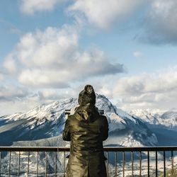 Rear view of person standing on snow covered mountain