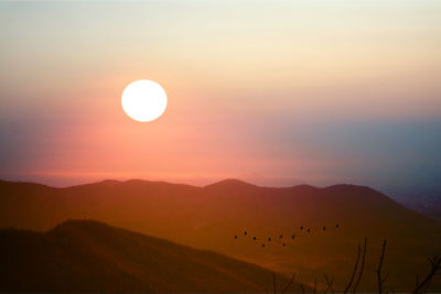 Scenic view of silhouette mountains against sky during sunset