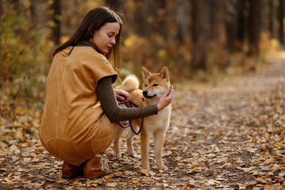 Young woman with dog on field during autumn